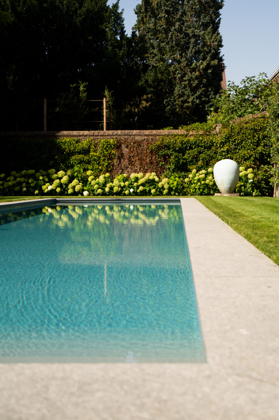 Ecologisch modern zwembad afgewerkt met betonsteen