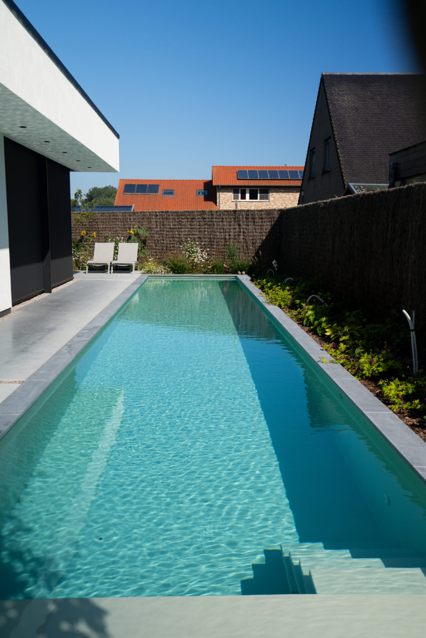 Strak zwembad design omringd door natuursteen scaled